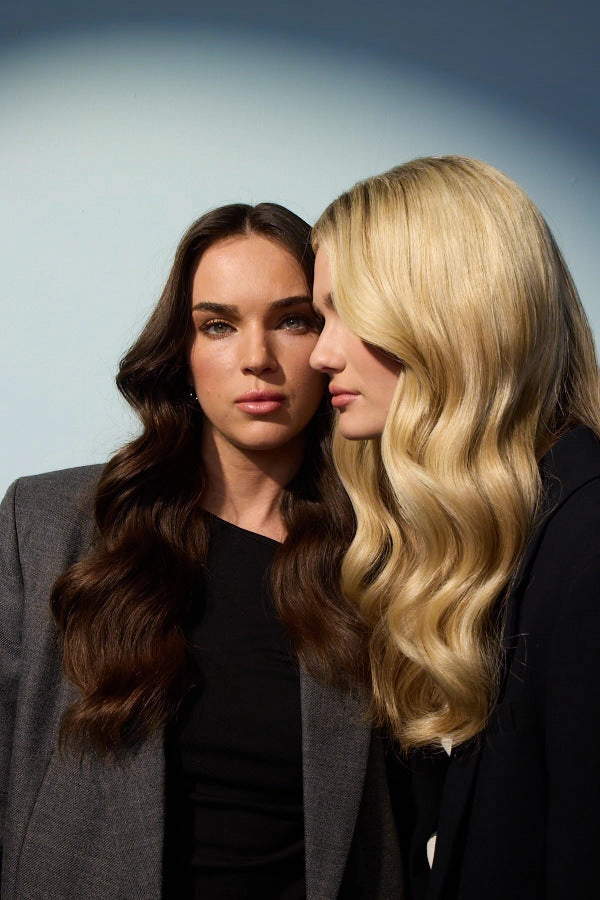 Two models with long wavy hair, one brunette and one blonde